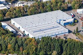 Flygfoto över ABUS Kransysteme GmbH:s anläggning i Marienheide-Rodt med produktionshallen för lätta kranar och logistikcentret.