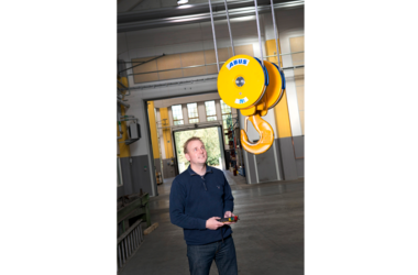 Glad anställd styr en ABUS-kran in i en produktionshall i Sverige