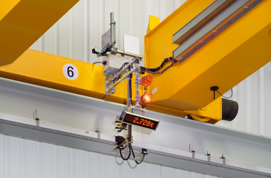 Bilden visar en tvåbalkad brokran. På chassibalk är en matris-LED-display monterad för att visa vikten på en last.Bilden visar en tvåbalkad brokran. På chassibalk är en matris-LED-display monterad för att visa vikten på en last.