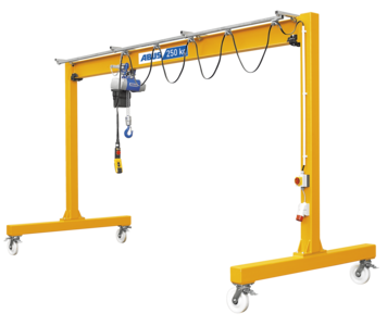 Bilden visar en portalkran monterad på rullar. En kedjetalja är fäst vid huvudbalkarna. På den högra portalstöttan finns huvudbrytaren och kontakten för strömförsörjningen.