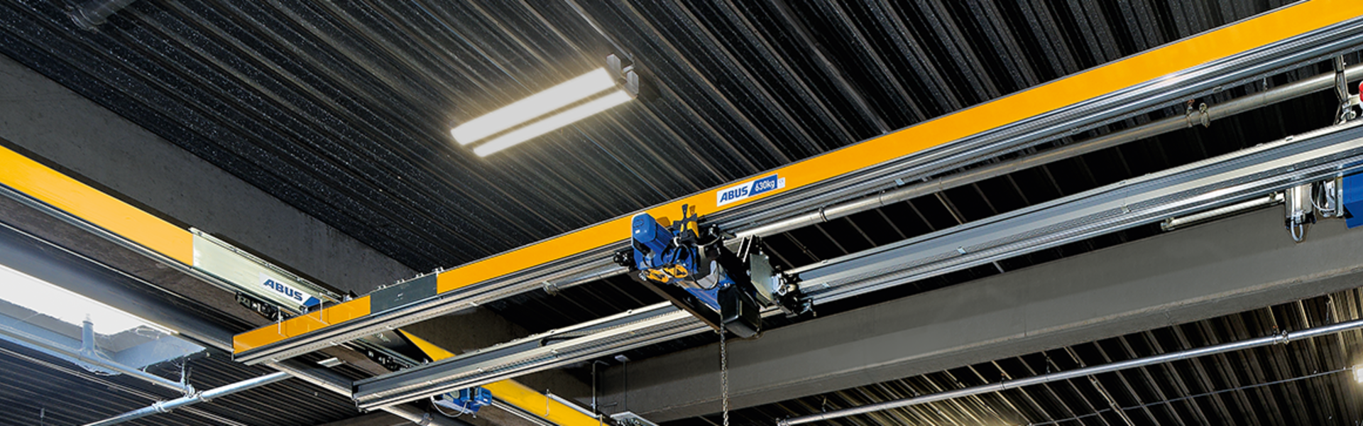 ABUS tvåbalkkran ZHB i industrihallen för säker transport och lyft av tunga laster.